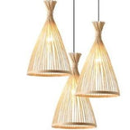 Three woven bamboo cone shades hanging from a round black canopy