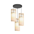 Three woven bamboo cylinder shades hanging from a round black canopy