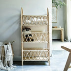 Three tier shelf with hand woven beige rattan shelves on a wood frame