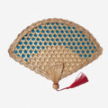 Traditional woven hand fan with a colored open weave and a red tassel