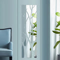 Tall acrylic door mirror with tree branch cutouts on a glass door
