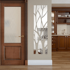 Tall acrylic door mirror with tree branch cutouts on a glass door