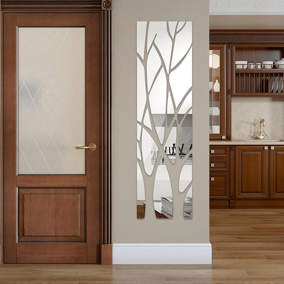 Tall acrylic door mirror with tree branch cutouts on a glass door