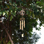 Bamboo wind chime with a carved tree of life medallion above the tubes