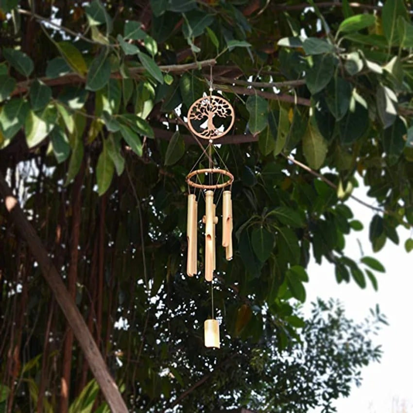 Bamboo wind chime with a carved tree of life medallion above the tubes