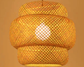 Two tier woven rattan lantern pendant glowing warm