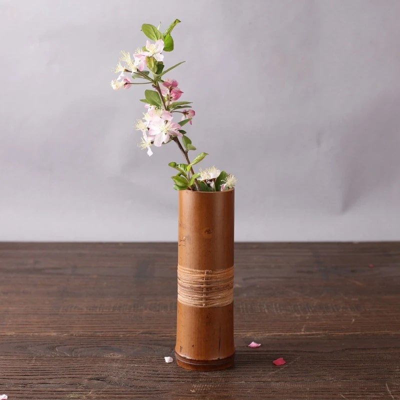 Brown bamboo tube vase with a woven band around the middle