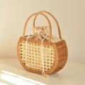 Compact round vintage hand woven rattan handbag with a rattan top handle
