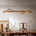 Long linear chandelier in wood look resin with an amber tone