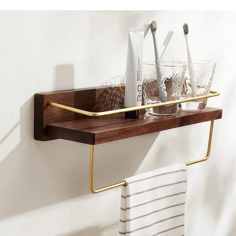 Walnut tone wood bathroom shelf with gold towel bar