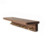 Walnut tone wood shelf with four brass key hooks