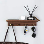 Walnut tone wood shelf with four brass key hooks