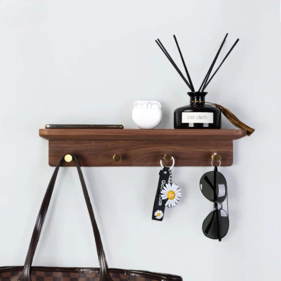 Walnut tone wood shelf with four brass key hooks