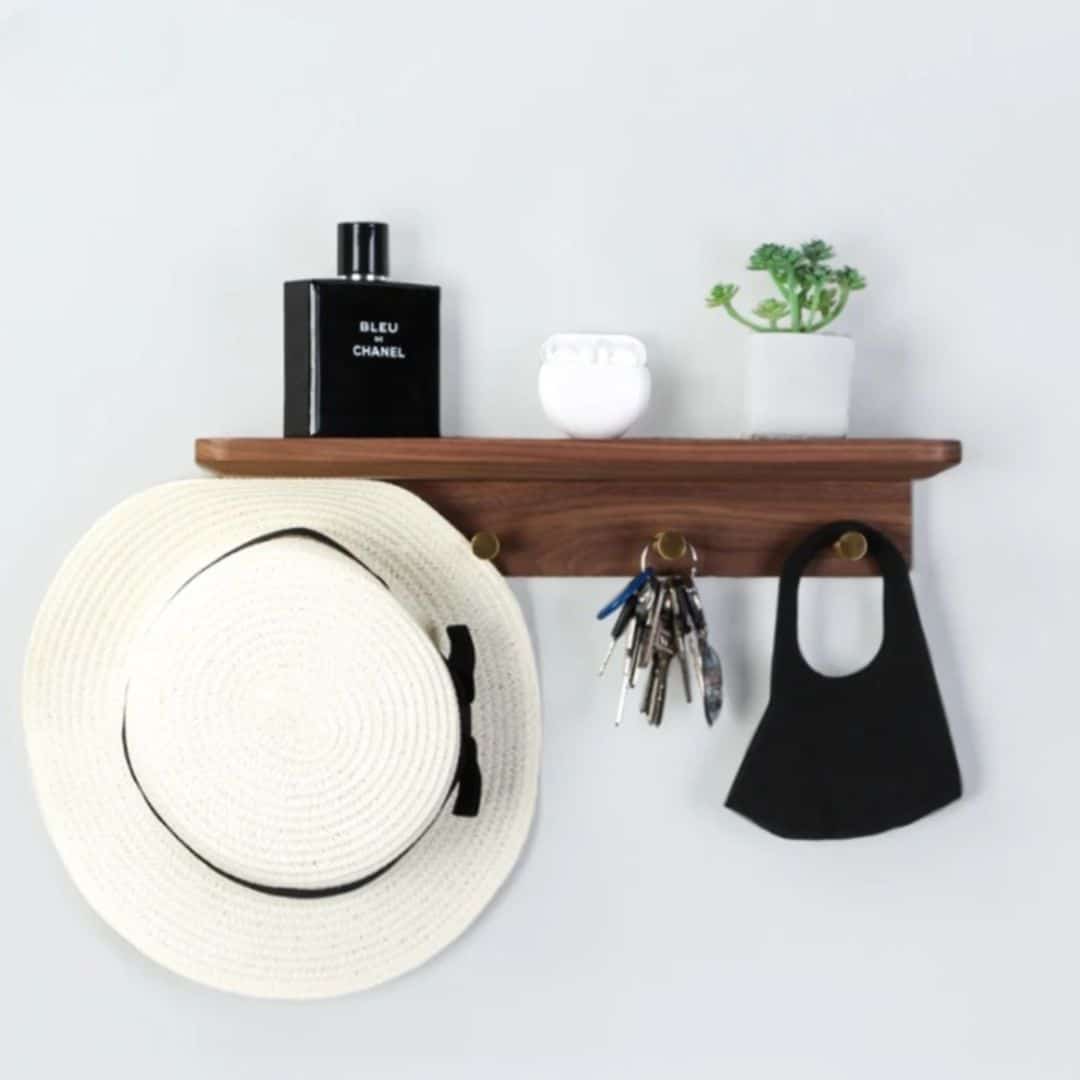 Walnut tone wood shelf with four brass key hooks