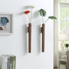 Two slim walnut wall vases holding single flowers