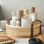 Round white rattan storage tray with stitched leather handles