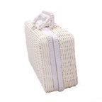 Small white woven rattan box shaped like a retro suitcase with straps