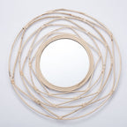 Round mirror framed by white rattan swirling loops