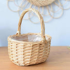 Round white wicker basket with tall handle holding pine cones