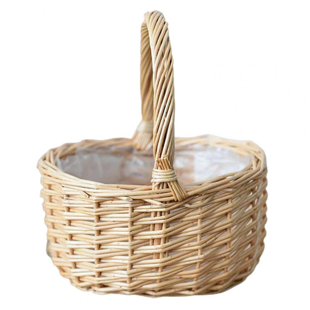 Round white wicker basket with tall handle holding pine cones