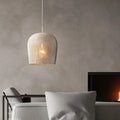 Small white woven rattan bell pendant in a living room