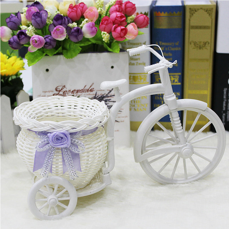 White woven tricycle holding a basket of faux flowers