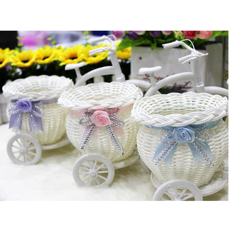 White woven tricycle holding a basket of faux flowers