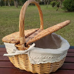 Oval wicker basket with flip lid and lace liner on a garden bench