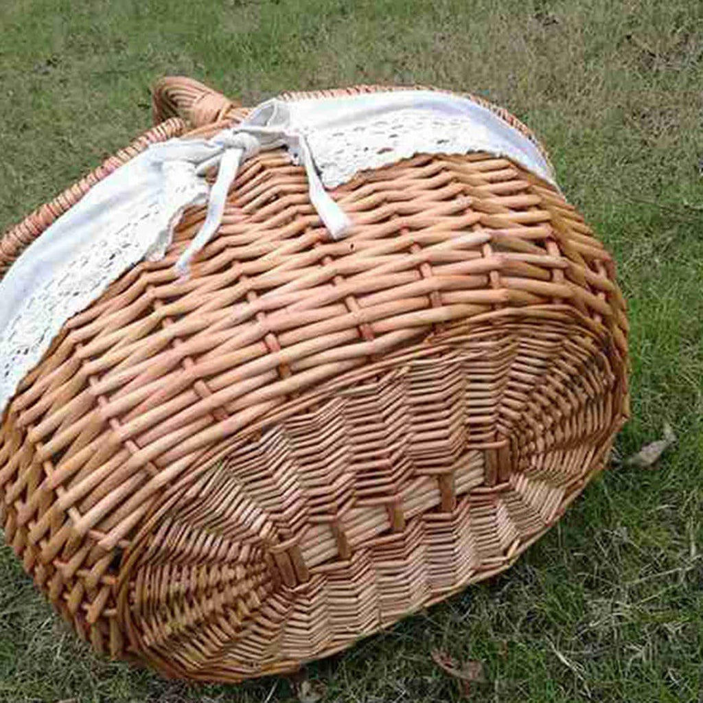 Oval wicker basket with flip lid and lace liner on a garden bench