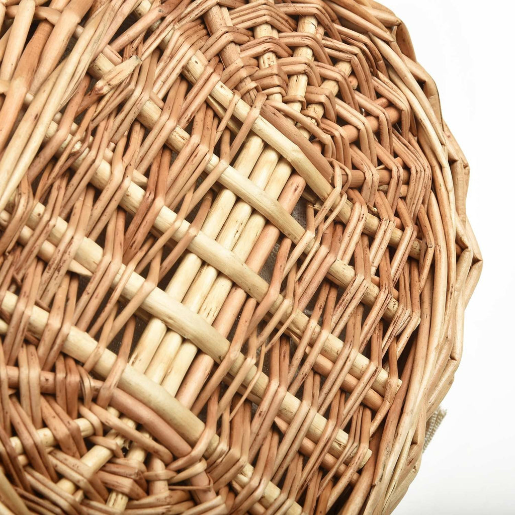 Oval wicker basket with flip lid and lace liner on a garden bench