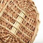 Oval wicker basket with flip lid and lace liner on a garden bench