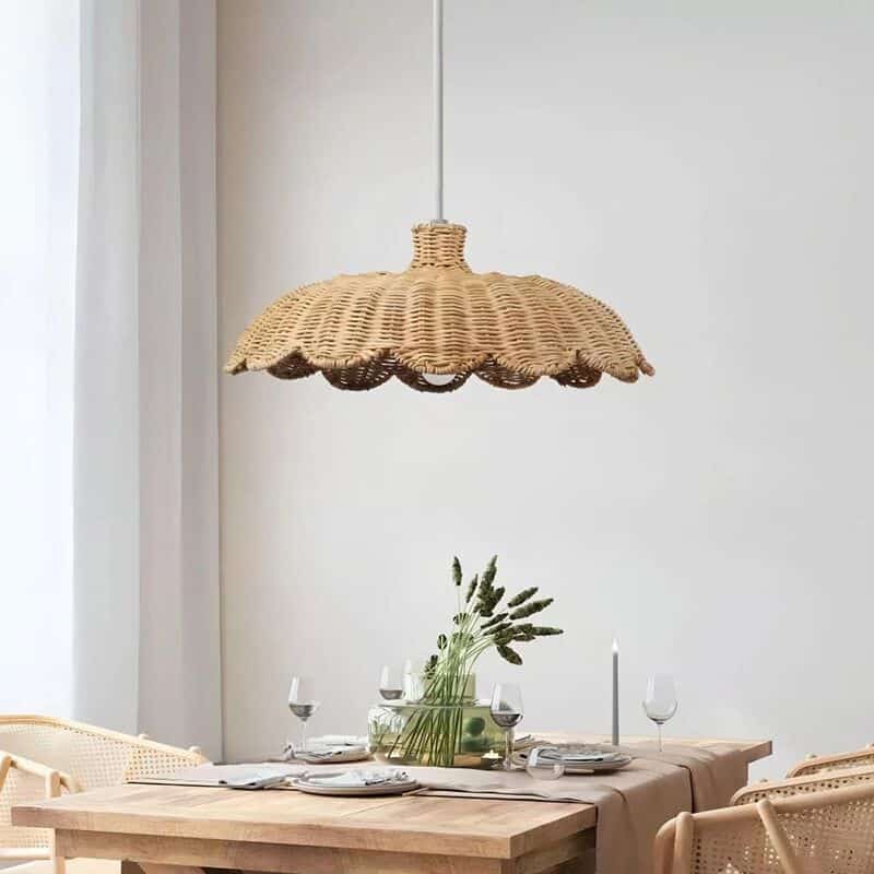 Wide low rattan pendant with wavy scalloped edge over a dining table