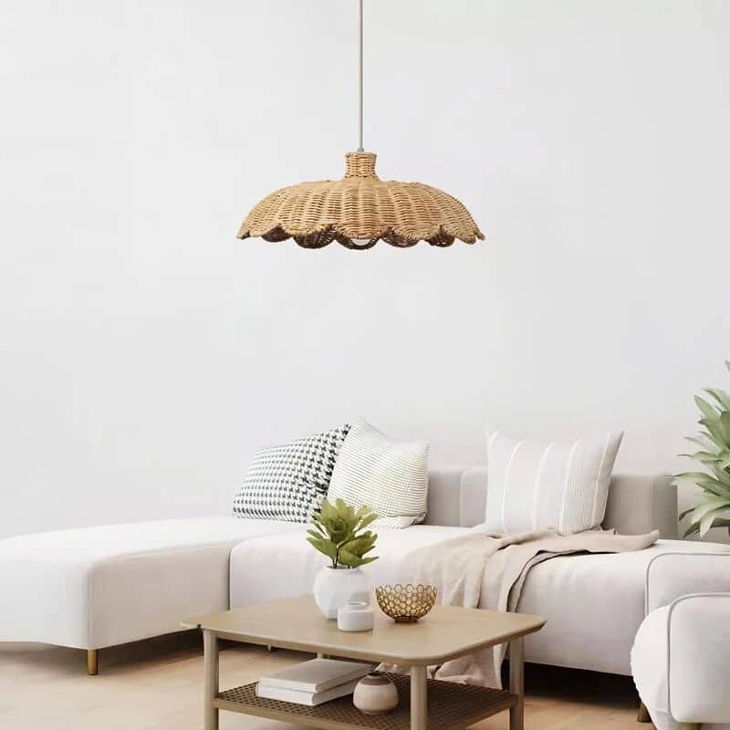 Wide low rattan pendant with wavy scalloped edge over a dining table