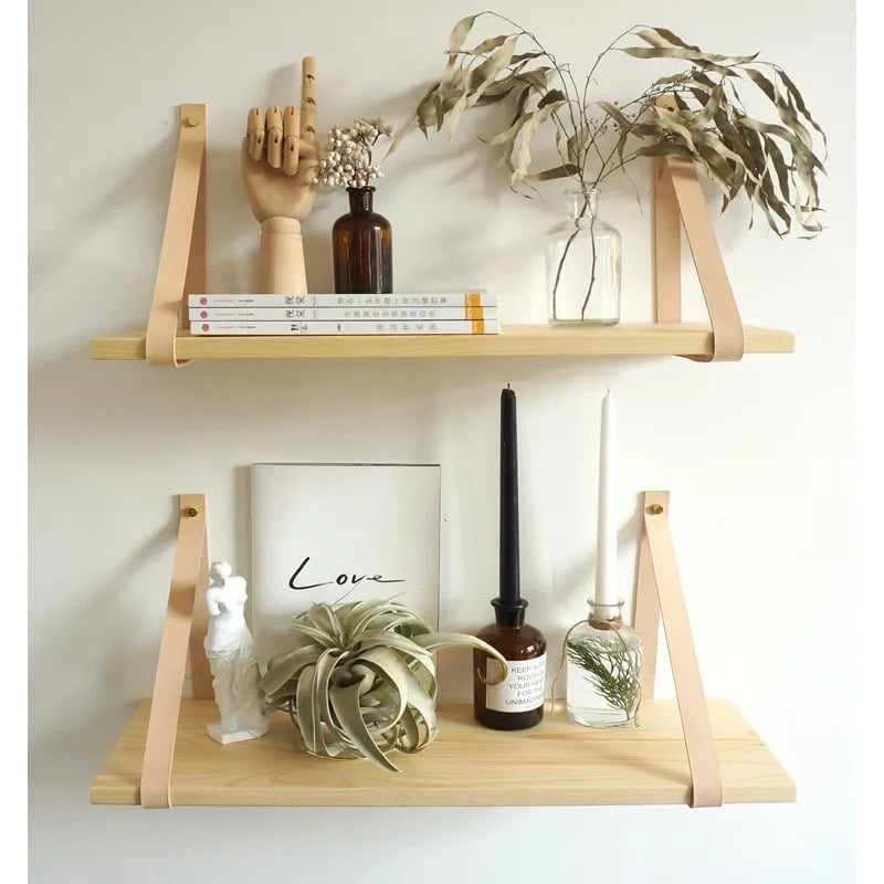 Brown wood wall shelf hung from two leather straps