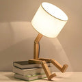 Playful wooden robot shaped bedside lamp with a fabric shade