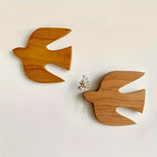 Two wooden swallow birds on a wall