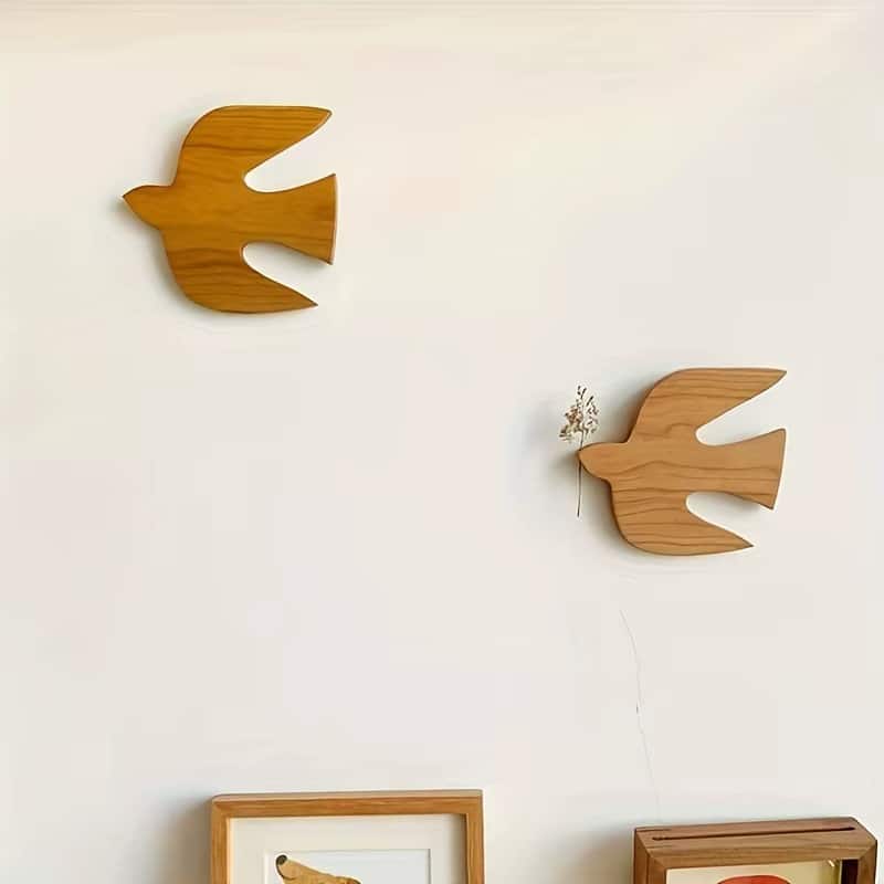 Two wooden swallow birds on a wall