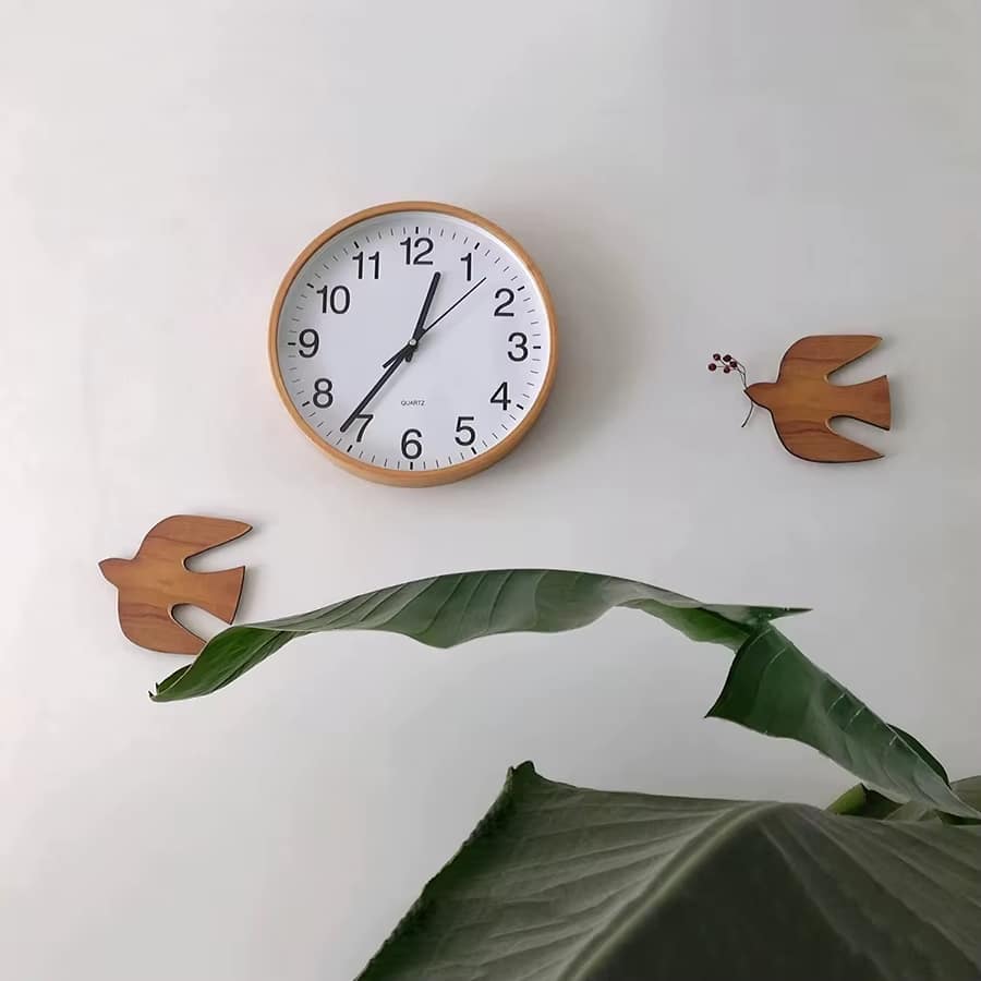 Two wooden swallow birds on a wall