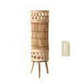 Tall woven bamboo floor lantern with an electric candle inside