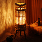 Tall woven bamboo floor lantern with an electric candle inside