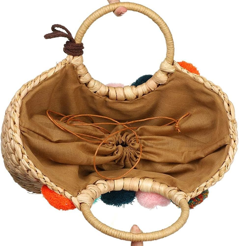 Hand woven basket bag with a round rigid handle and a cascade of colorful pompoms