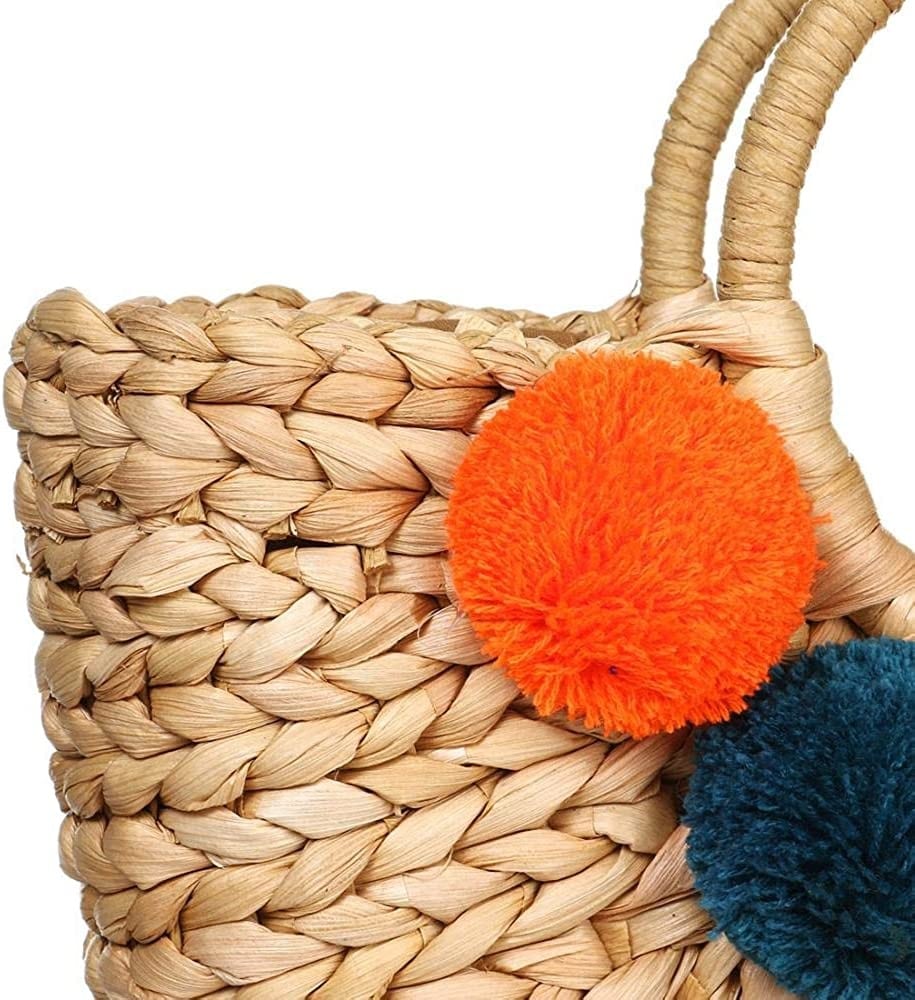 Hand woven basket bag with a round rigid handle and a cascade of colorful pompoms