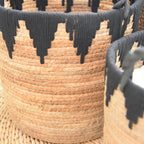Woven basket with black zigzag pattern and black handles