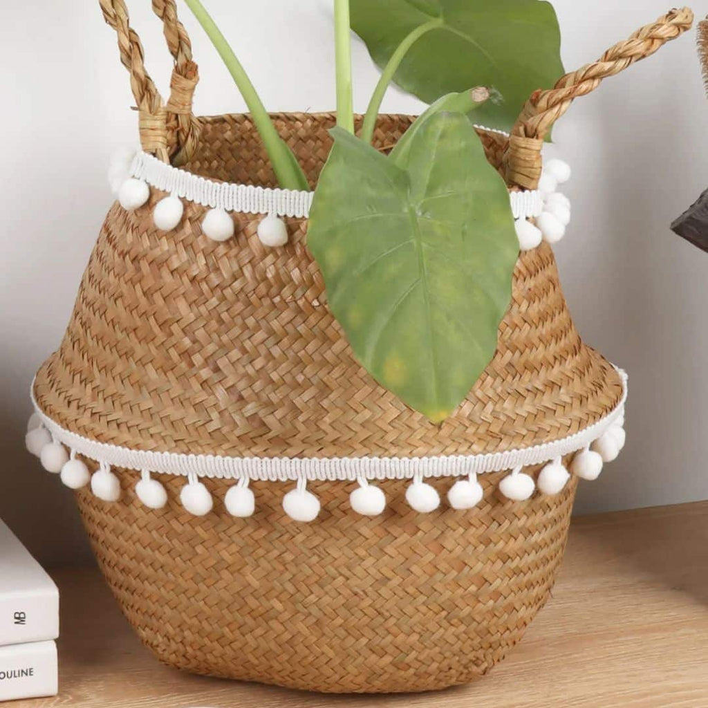 Woven belly basket trimmed with white pom poms
