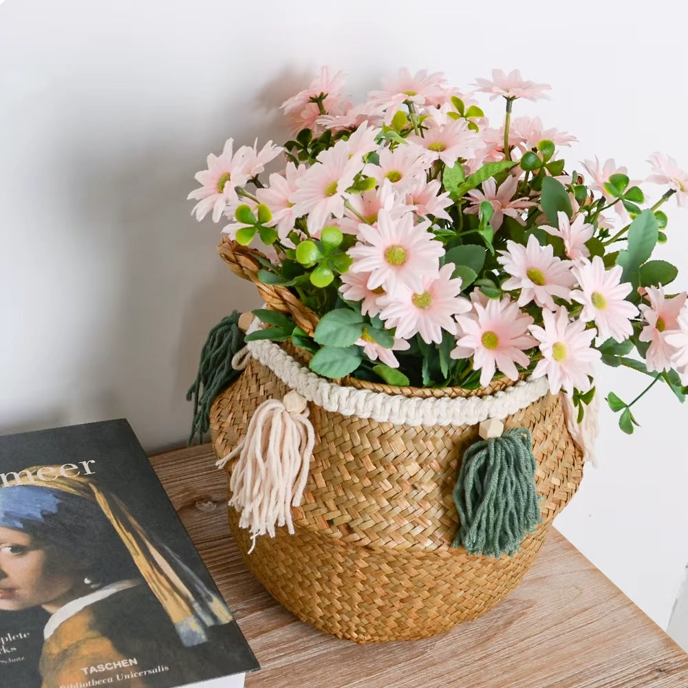 Woven belly basket with green and white tassels holding flowers