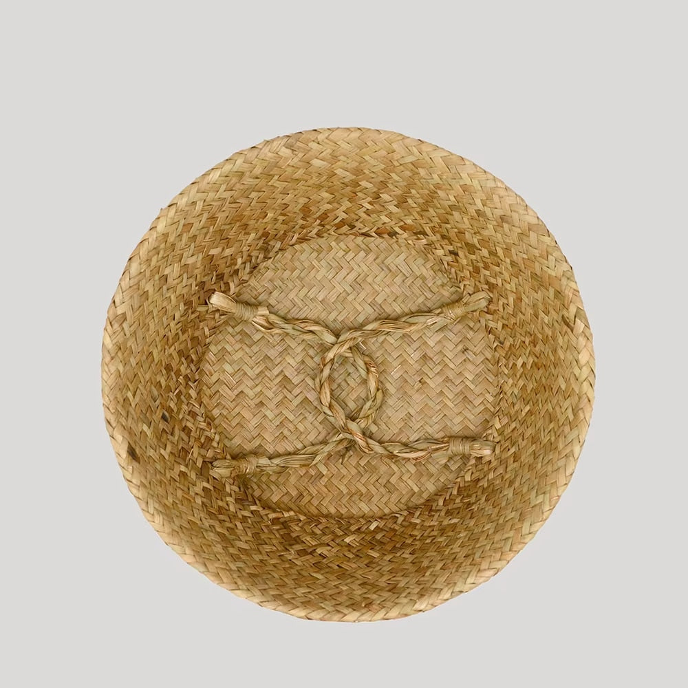 Woven belly basket with green and white tassels holding flowers