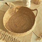 Cat curled up in a round woven cat bed with ears