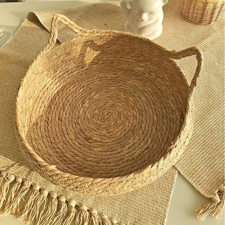 Cat curled up in a round woven cat bed with ears