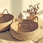 Cat curled up in a round woven cat bed with ears