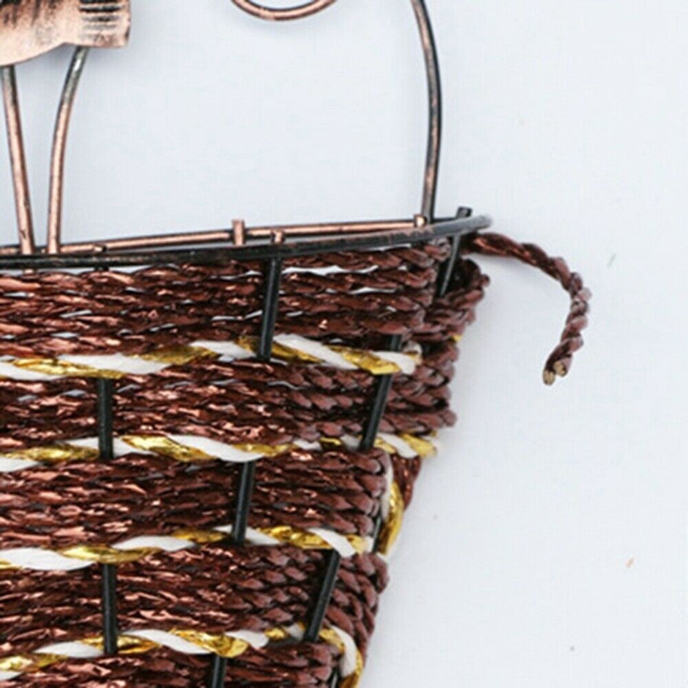 Woven cone shaped wall planter filled with pink flowers